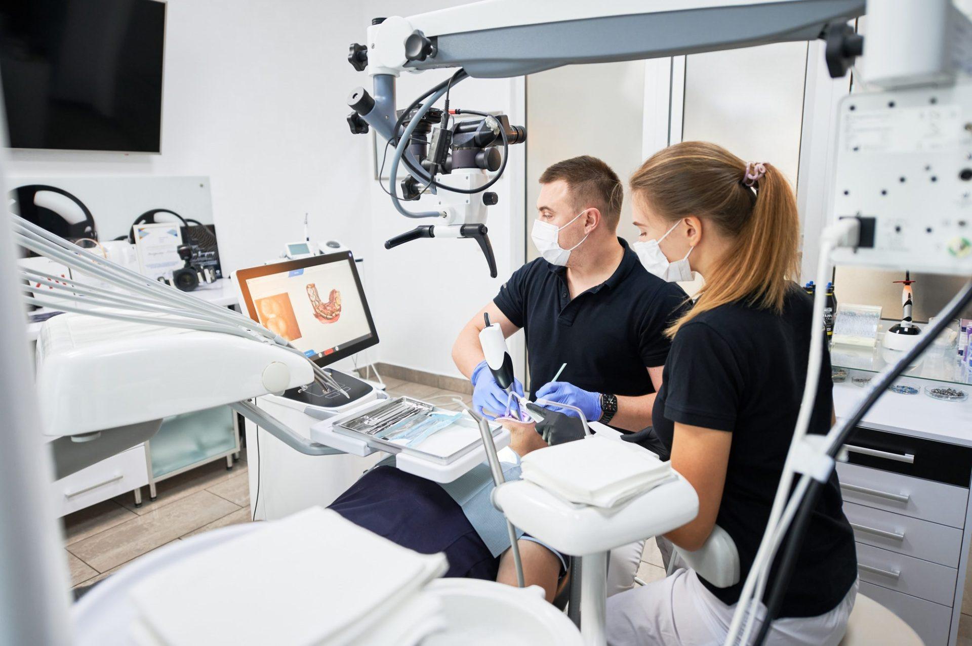 dentist scanning patient s teeth with modern machine for intraoral scanning