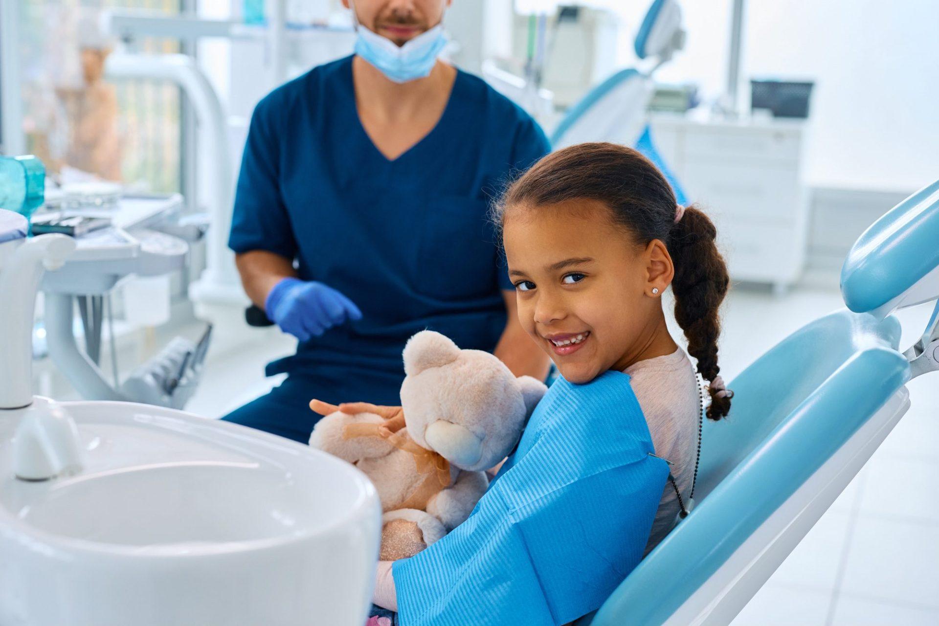 happy black little girl at dentist s office looking at camera