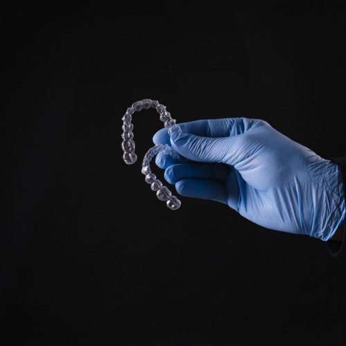 closeup of hand in gloves holding transparent mouthguards isolated on black background r8e7uxs97et87qw6q7tmhtklfj3q42aig4giuemxe0 rr58wot391qnm890pnbw5k8s1n6mgziqsyojmrzers