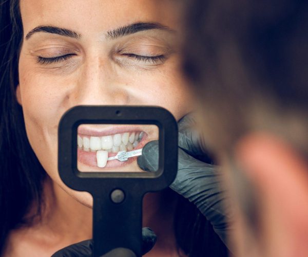 dentist picking sample of teeth veneer for woman
