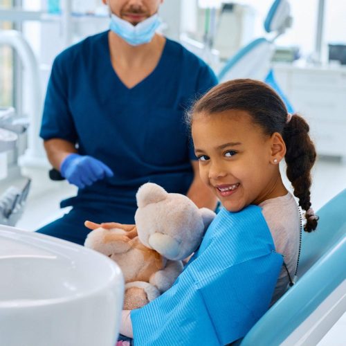 happy black little girl at dentist s office looking at camera
