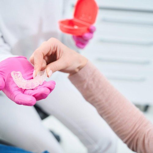 woman takes a special mouthguard from hands of an orthodontist r8e7ukmijqb7p7fav24uiww544wl4au9qbbq4j6ft4