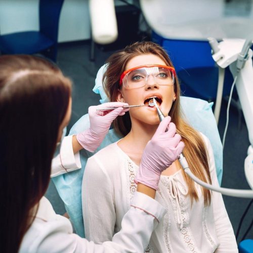 young woman at the dentist s chair during a dental procedure overview of dental caries prevention